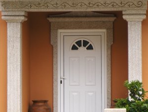 Porta de entrada com arco e pilares de suporte da varanda, produzidos com granito da Sopedra.