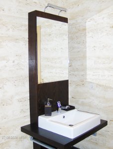 Lavatório da casa de banho que combina perfeitamente com as paredes revestidas com mármore travertino da Sopedra.
